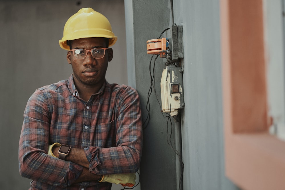 Business owner in a plaid work shirt and hard hat standing at a jobsite