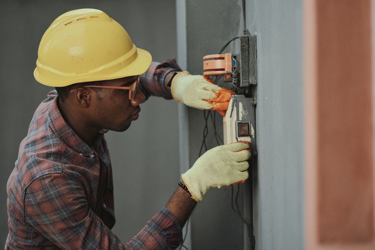 Technician wiring an exterior light fixture on a wall